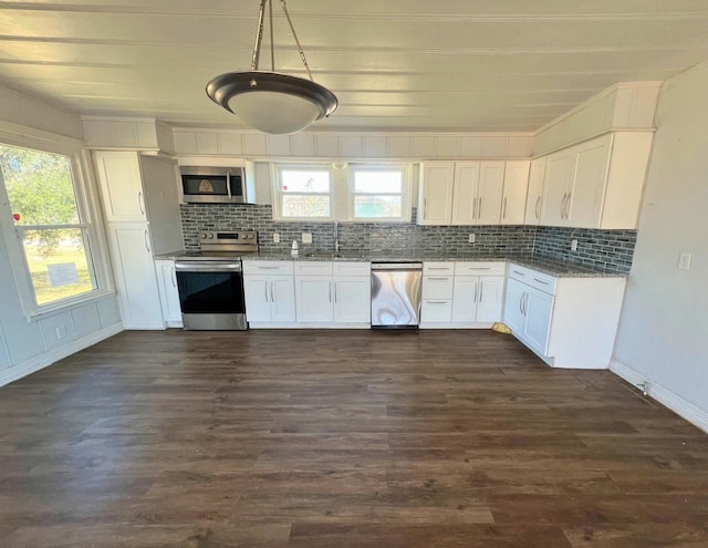 kitchen with appliances with stainless steel finishes, decorative light fixtures, tasteful backsplash, white cabinetry, and light stone countertops