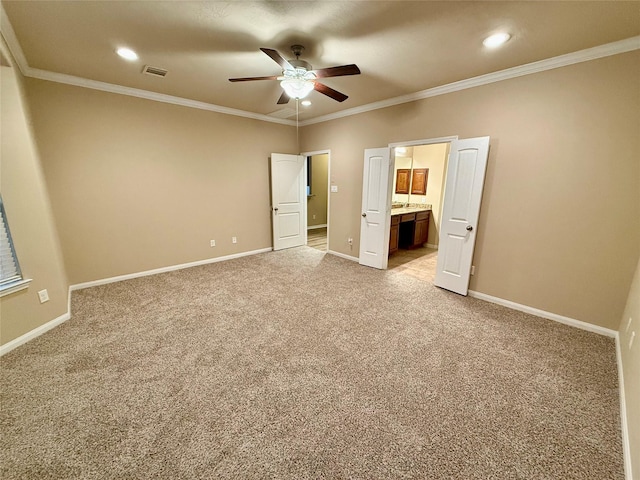 unfurnished bedroom with crown molding, light colored carpet, ensuite bathroom, and ceiling fan