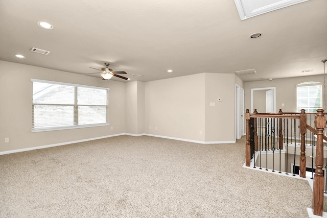 carpeted spare room featuring ceiling fan