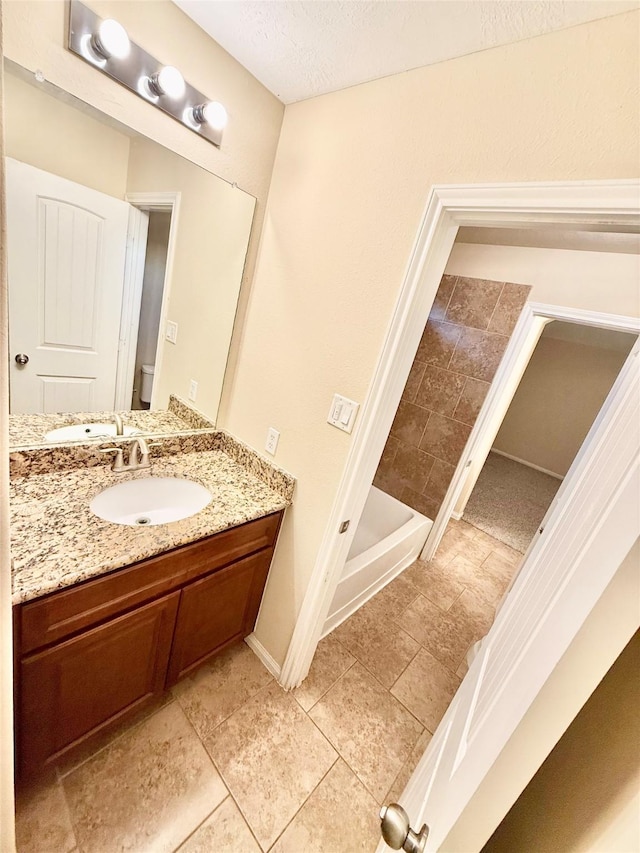 bathroom with vanity, tile patterned flooring, and a textured ceiling