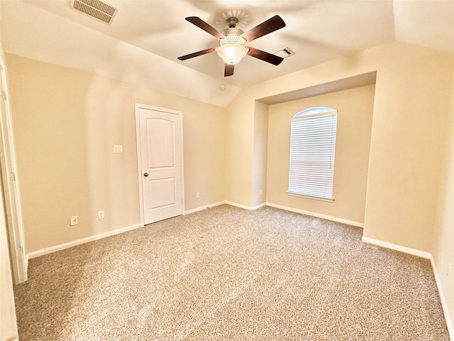 empty room featuring lofted ceiling, ceiling fan, and carpet flooring