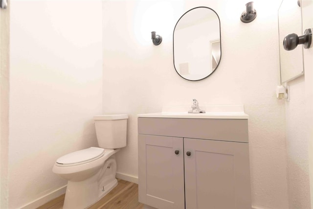 bathroom with hardwood / wood-style flooring, vanity, and toilet