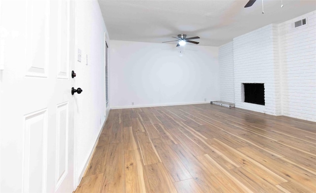 unfurnished living room with hardwood / wood-style flooring, ceiling fan, and a fireplace