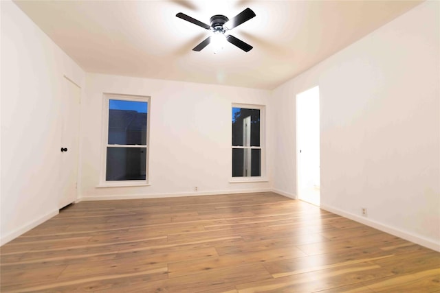 empty room with ceiling fan and light hardwood / wood-style flooring