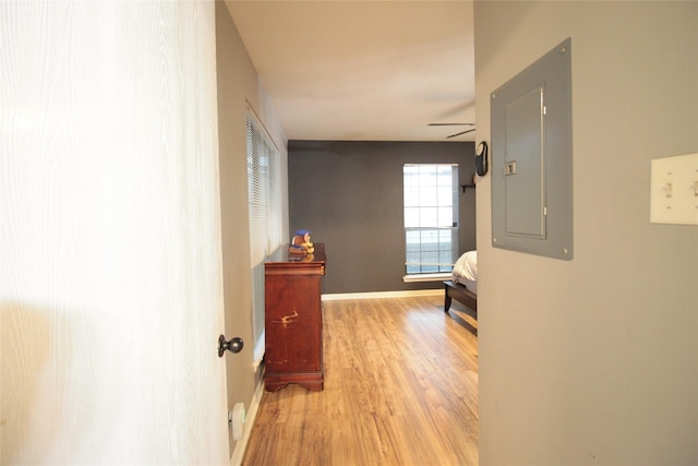 hallway with electric panel and light hardwood / wood-style floors