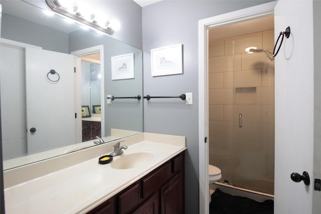 bathroom featuring vanity, an enclosed shower, and toilet