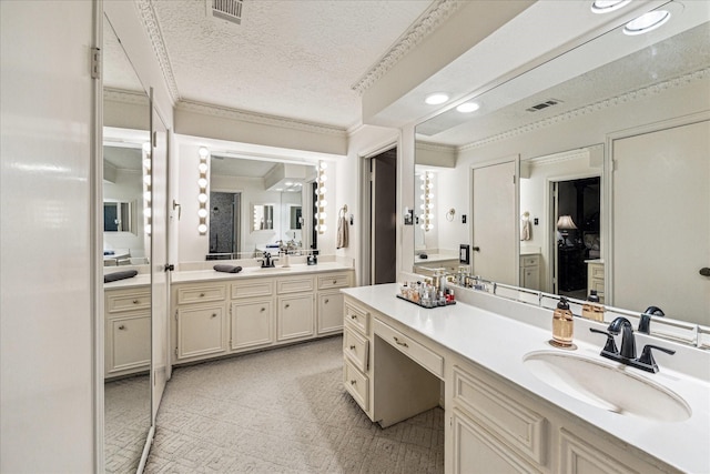 bathroom with ornamental molding, a textured ceiling, and vanity