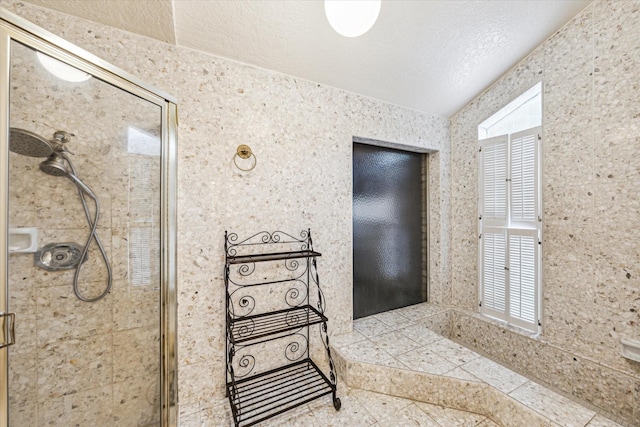 bathroom with tiled shower and a textured ceiling