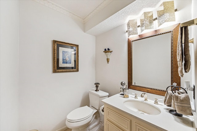 bathroom with crown molding, vanity, and toilet