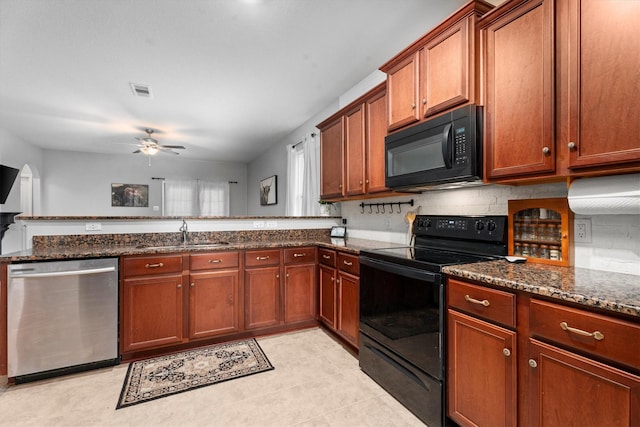 kitchen with black appliances, brown cabinetry, dark stone countertops, and a sink