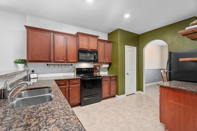 kitchen with sink, black appliances, and dark stone counters