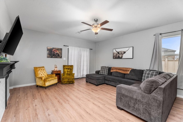 living room featuring ceiling fan and light hardwood / wood-style floors