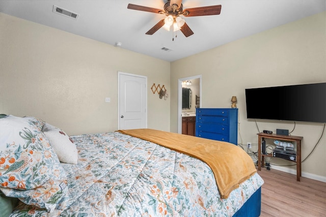 bedroom with ensuite bath, light hardwood / wood-style flooring, and ceiling fan