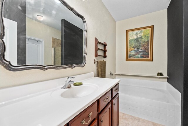 bathroom featuring vanity, tiled bath, and tile patterned floors