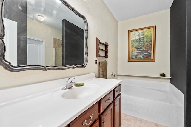 bathroom featuring tile patterned flooring, a garden tub, and vanity