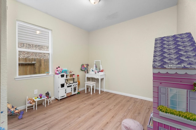 rec room featuring light wood-type flooring and baseboards