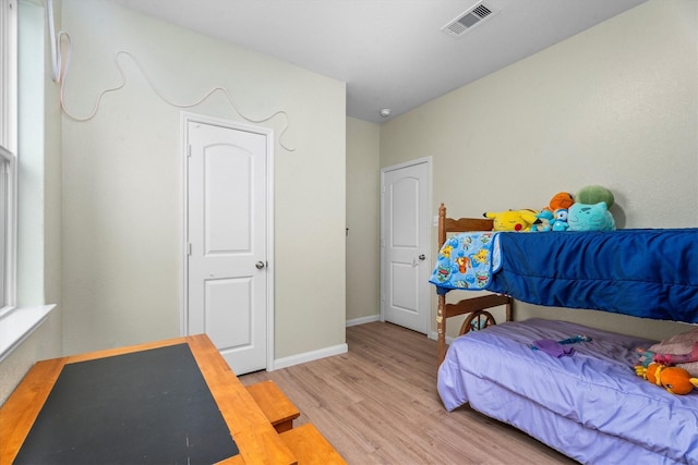 bedroom featuring light wood-type flooring, baseboards, and visible vents