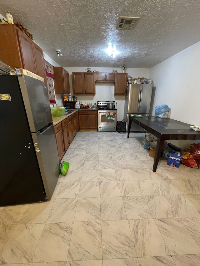 kitchen with stainless steel appliances, sink, and a textured ceiling