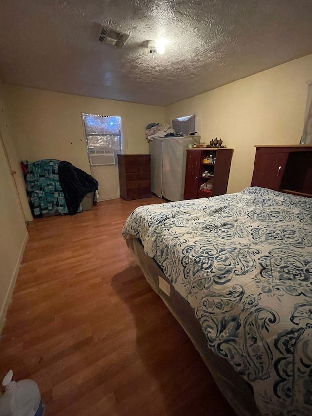 bedroom featuring hardwood / wood-style floors and a textured ceiling