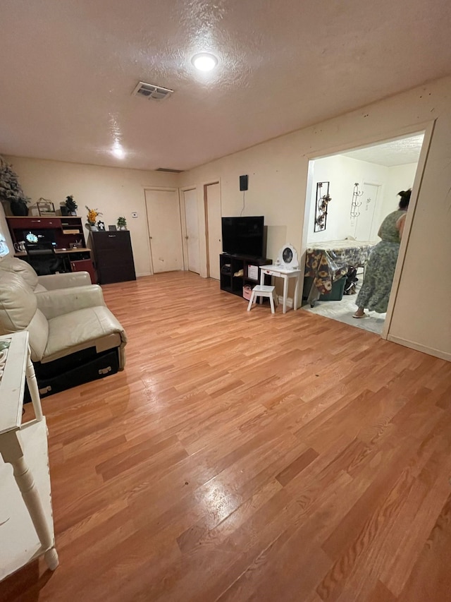 living room featuring a textured ceiling and light hardwood / wood-style flooring