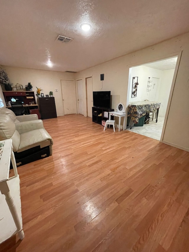 living room featuring wood-type flooring and a textured ceiling