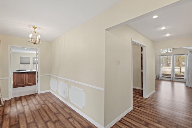 hall featuring hardwood / wood-style floors and an inviting chandelier