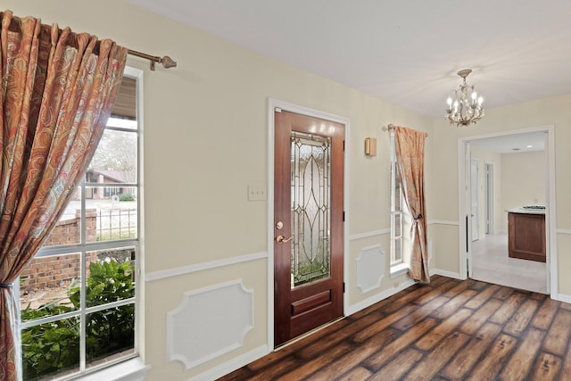 entryway with a notable chandelier and dark hardwood / wood-style flooring