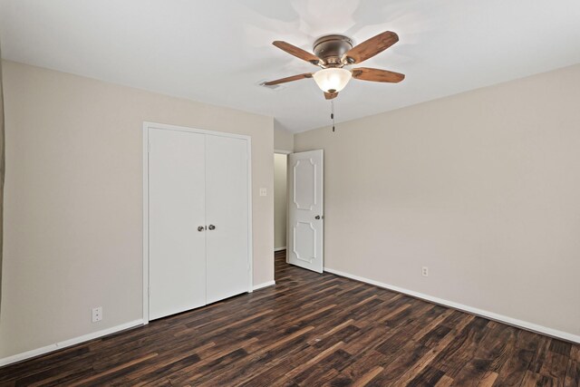 unfurnished bedroom featuring ceiling fan, dark hardwood / wood-style flooring, and a closet