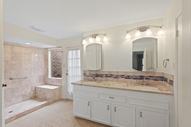 bathroom with vanity, tiled shower, backsplash, and tile patterned floors