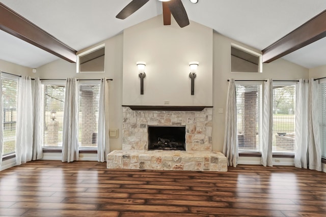 unfurnished living room featuring a stone fireplace, vaulted ceiling with beams, and dark hardwood / wood-style flooring