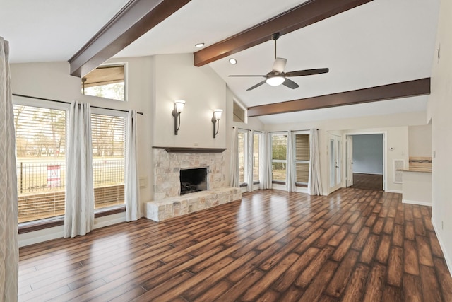 unfurnished living room featuring dark hardwood / wood-style flooring, beam ceiling, a fireplace, and ceiling fan