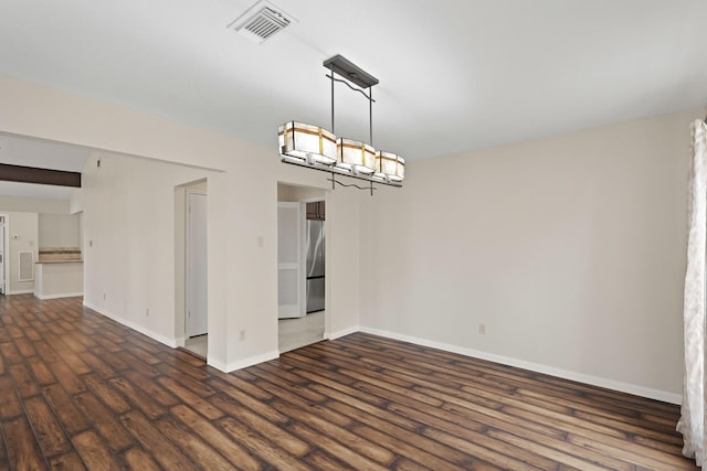 unfurnished room with dark hardwood / wood-style flooring and a chandelier