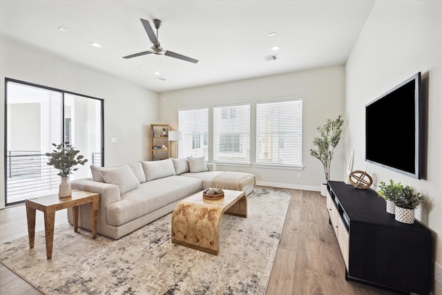 living room featuring light hardwood / wood-style floors and ceiling fan