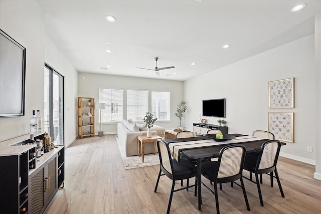 dining space with ceiling fan and light wood-type flooring