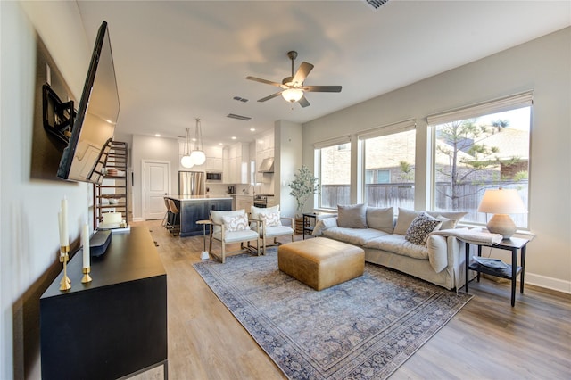 living room featuring ceiling fan and hardwood / wood-style floors