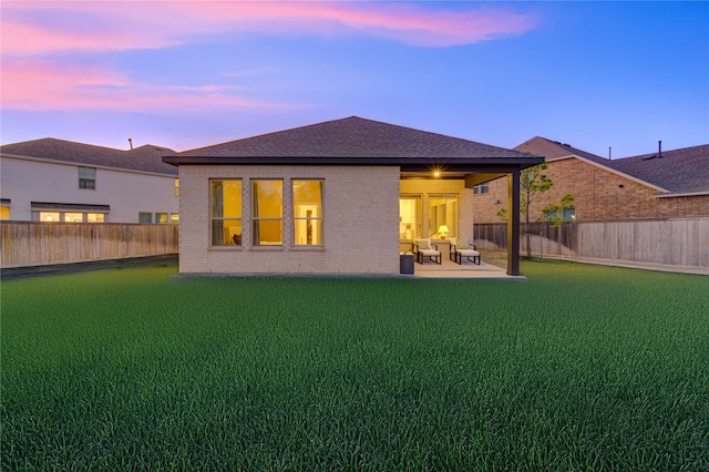 back house at dusk featuring a patio area