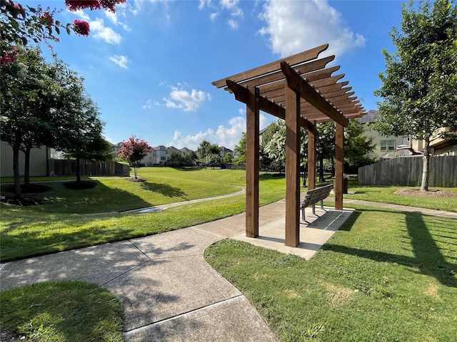 view of property's community with a yard and a pergola