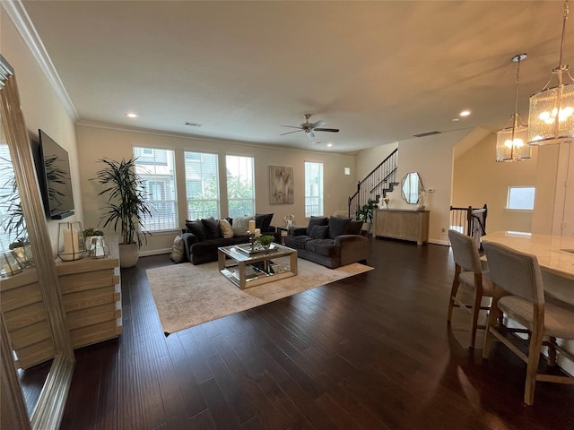 living room featuring ornamental molding, dark hardwood / wood-style floors, and ceiling fan with notable chandelier