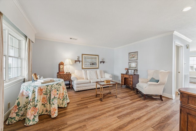 living room with hardwood / wood-style flooring, ornamental molding, and plenty of natural light