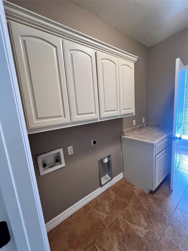 clothes washing area featuring electric dryer hookup, hookup for a washing machine, and cabinets