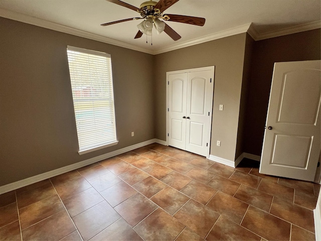 unfurnished bedroom with tile patterned floors, ornamental molding, a closet, and ceiling fan