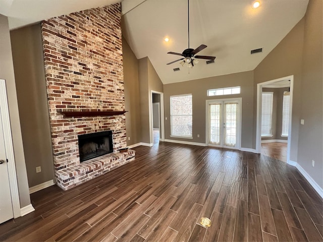 unfurnished living room with ceiling fan, high vaulted ceiling, a fireplace, and french doors