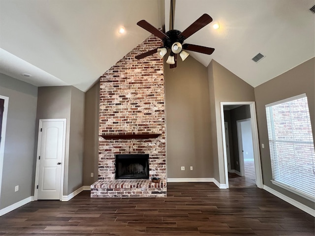 unfurnished living room with dark hardwood / wood-style flooring, a brick fireplace, high vaulted ceiling, and ceiling fan