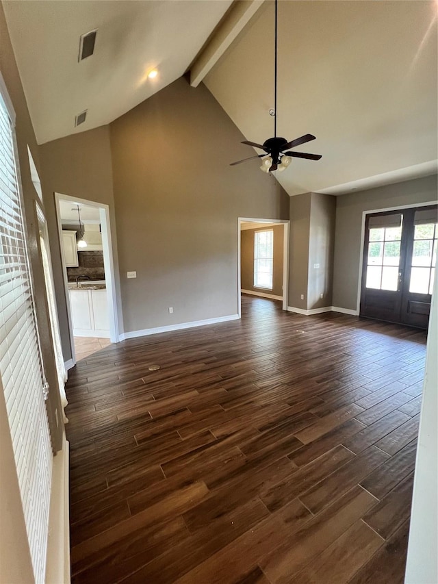 unfurnished living room featuring dark hardwood / wood-style floors, high vaulted ceiling, ceiling fan, beam ceiling, and french doors