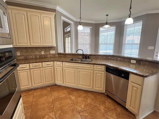 kitchen featuring sink, hanging light fixtures, ornamental molding, stainless steel appliances, and cream cabinets