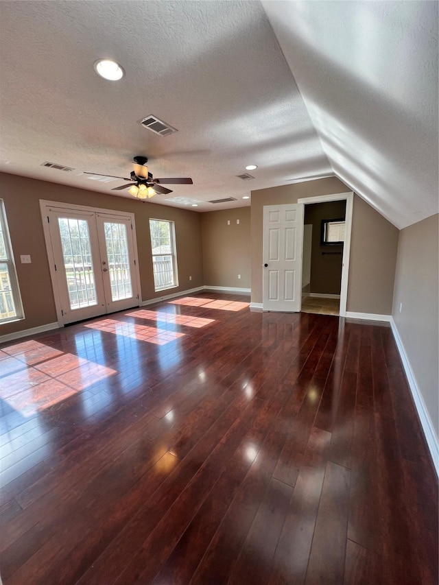 interior space with lofted ceiling, dark hardwood / wood-style flooring, and a textured ceiling