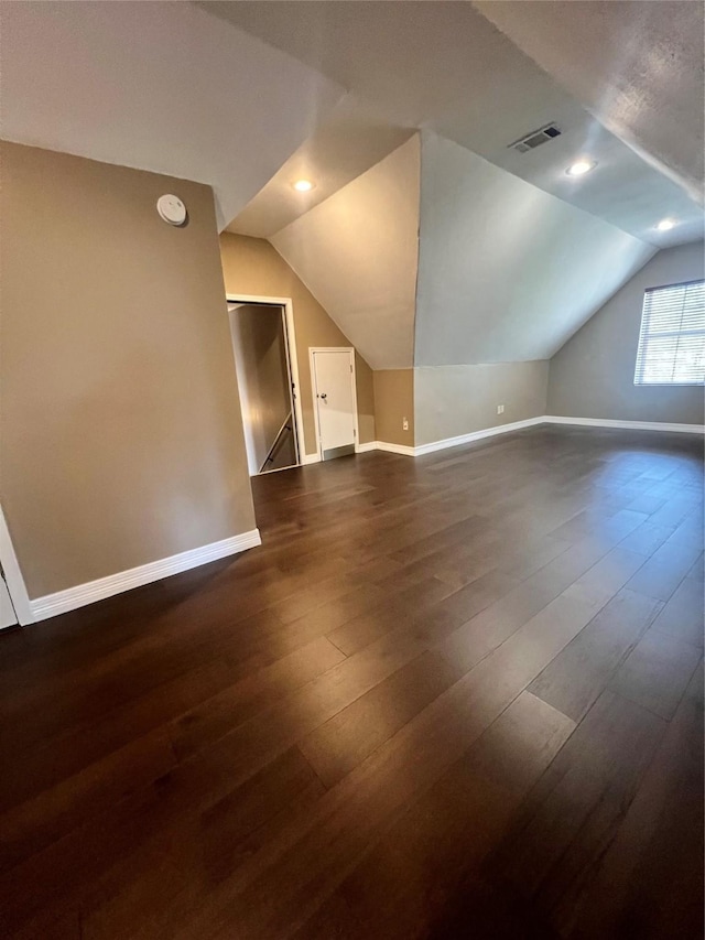 additional living space with dark wood-type flooring and vaulted ceiling