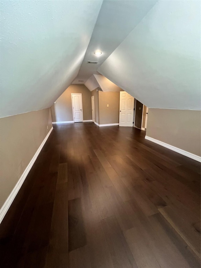 additional living space featuring vaulted ceiling and dark hardwood / wood-style floors