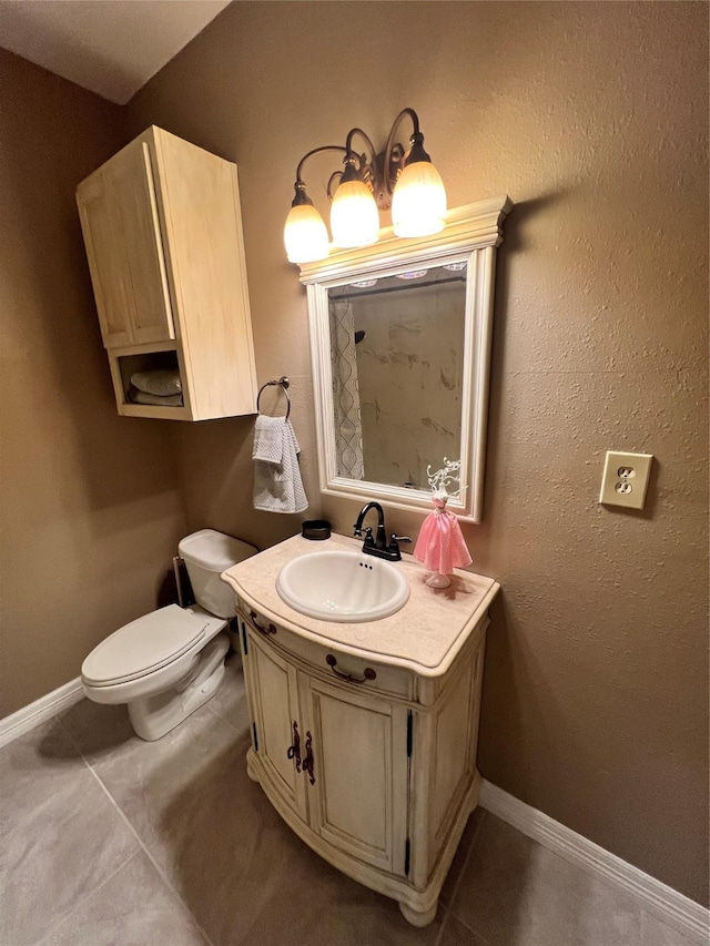 bathroom featuring vanity, tile patterned floors, and toilet