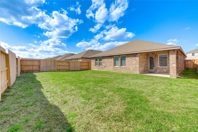 rear view of house featuring a yard and a patio area